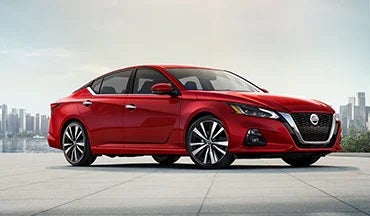 2023 Nissan Altima in red with city in background illustrating last year's 2022 model in Nissan City of Springfield in Springfield NJ